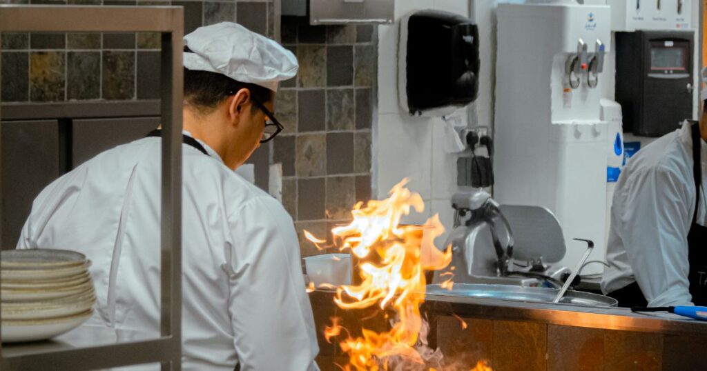 Cozinheiro queimado com óleo ou gás na cozinha industrial